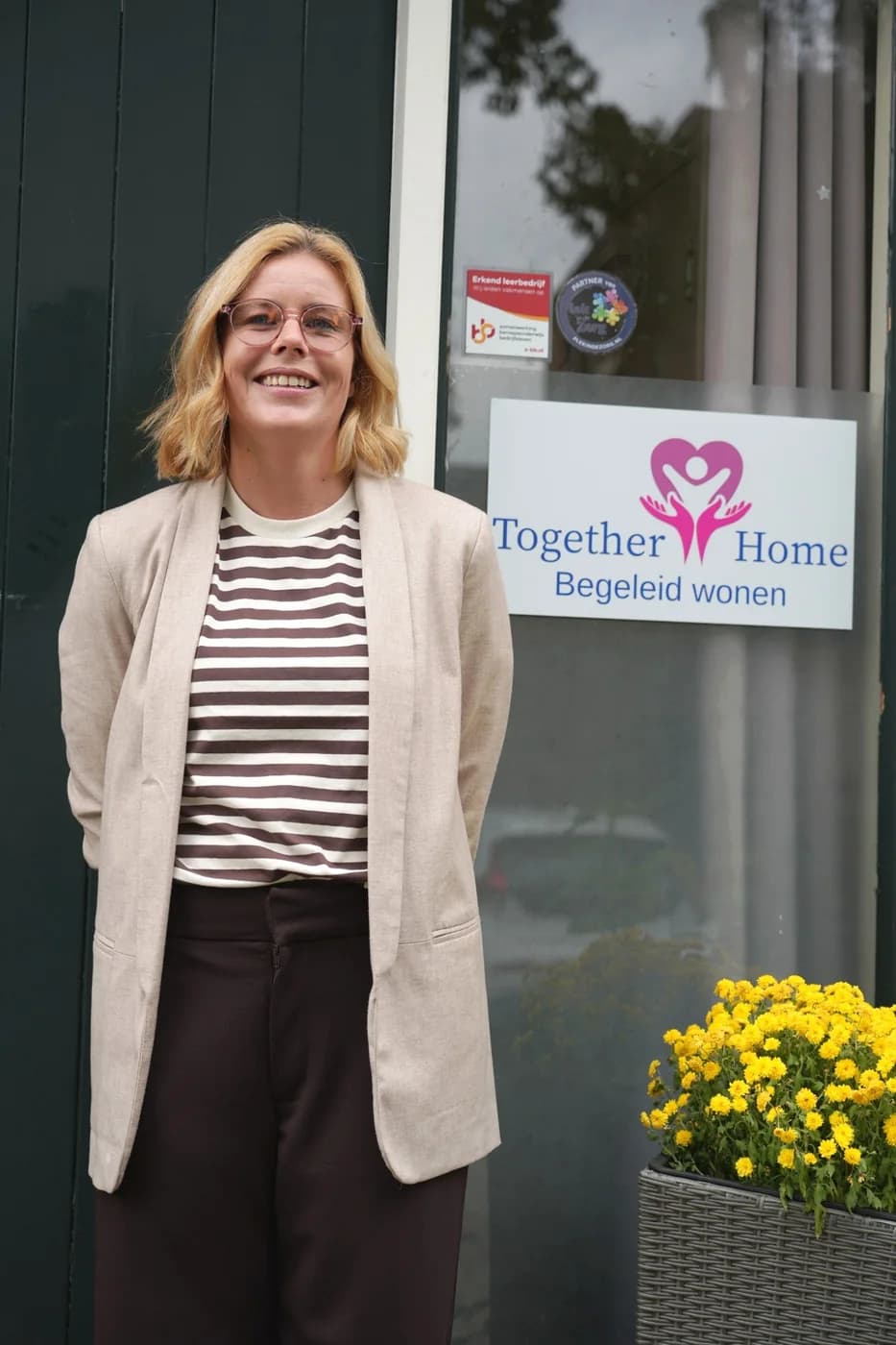 Aukje, woonbegeleider bij Together Home, voor de ingang aan de Albatrosstraat