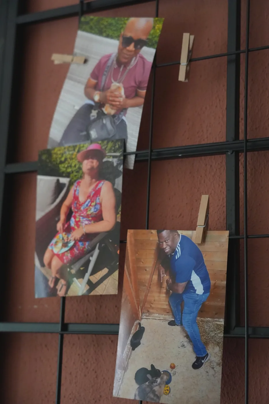 Foto's van bewoners met wasknijpers aan een zwart wandrek
